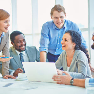 Group of business partners looking at smiling female explaining her ideas at meeting